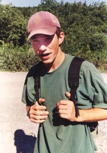 18 year old Matt Gauger hold knapsack straps and grinning into camara